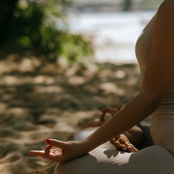 Person meditating peacefully outdoors, representing overall well-being.